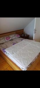 a large white bed sitting in a room at Vikendica Rosi 