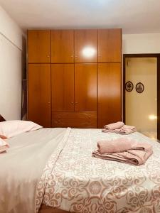 Schlafzimmer mit einem großen Bett und Holzschränken in der Unterkunft Elaiones house in Thessaloniki