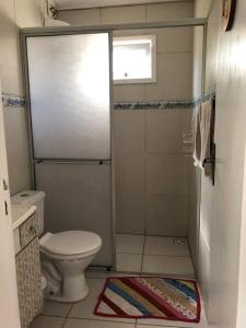 a small bathroom with a toilet and a shower at Casa Completa 2 Quartos in Penha