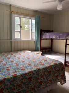 a bedroom with a bed and a window and bunk beds at Casa Completa 2 Quartos in Penha