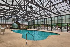 ein großer Pool in einem Gebäude mit Fenstern in der Unterkunft Tennessee Cabin with Balcony, Hot Tub and Pool Access! in Sevierville
