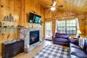 ein Wohnzimmer mit einem Kamin und einem Sofa in der Unterkunft Tennessee Cabin with Balcony, Hot Tub and Pool Access! in Sevierville