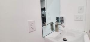 a white bathroom with a sink and a mirror at One unit of a fully renovated duplex near FSU in Tallahassee