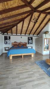 a bedroom with a large bed with a wooden ceiling at Glamping con jacuzzi Mirador Jarana Villa de Leiva in Villa de Leyva