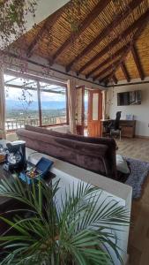 a living room with a couch and a large window at Glamping con jacuzzi Mirador Jarana Villa de Leiva in Villa de Leyva