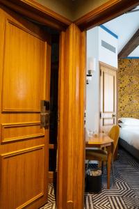 Una puerta a una habitación con una mesa y una cama en Hôtel De Fleurie en París