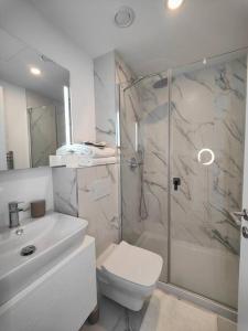 een badkamer met een douche, een toilet en een wastafel bij Luxury Apartment/High Floor/Stunning Views/Parking in Gibraltar