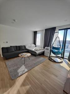 een woonkamer met een zwarte bank en een stoel bij Luxury Apartment/High Floor/Stunning Views/Parking in Gibraltar