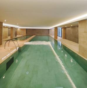 een zwembad met groen water in een gebouw bij Luxury Apartment/High Floor/Stunning Views/Parking in Gibraltar
