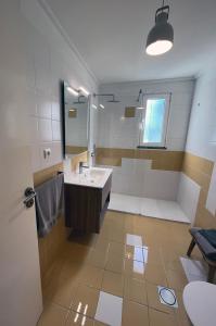 ein Badezimmer mit Waschbecken und Spiegel in der Unterkunft Marias sea cottage in Funchal