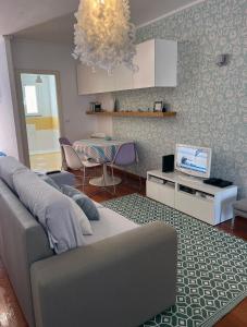 sala de estar con sofá, TV y mesa en Marias sea cottage, en Funchal
