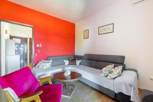 a living room with a couch and a red wall at Apartments Alen in Trogir