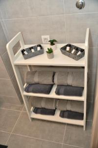 een witte plank met handdoeken in de badkamer bij LUX APARTMAN PANORAMA in Bečej