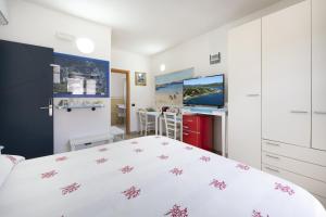 帕勞的住宿－L'Orso e il Mare (Adults Only)，卧室配有白色的床和电视