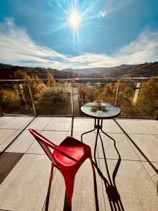 a red chair and a table on a balcony at the beskid view in Wisła