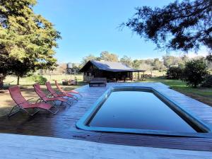 a swimming pool on a deck with chairs and a pavilion at El Remanso in Villa Residencial Laguna Brava