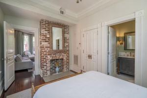 1 dormitorio con chimenea de ladrillo y 1 cama en Waverly Suite at Mirabelle, en Savannah