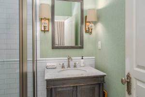 uma casa de banho com um lavatório e um espelho em Leland Suite at Mirabelle em Savannah