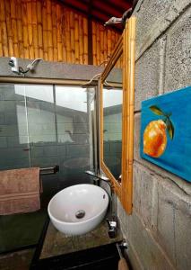 baño con lavabo y una pintura de naranja en Chalet Zen Bella Vista en Ángeles