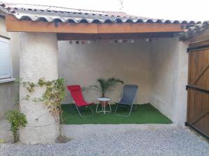 2 stoelen en een tafel in een patio bij SCI la malinoise in Albon