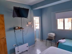 a blue room with a bed and a television on the wall at LOS RULITOS Departamentos Temporarios in San Salvador de Jujuy