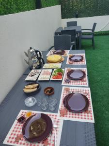 istanbul airport family suites hotel في Arnavutköy: طاولة نزهة مع أطباق من الطعام عليها