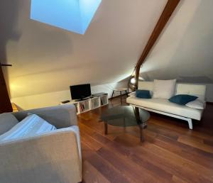 a living room with a couch and a table at Le jardin des Vérottes in Beaune