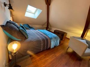 1 dormitorio con cama, ventana y silla en Le jardin des Vérottes, en Beaune