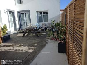a patio with a picnic table in front of a house at Loc5c in Noirmoutier-en-l'lle