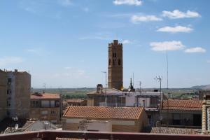 Blick auf eine Stadt mit einem Uhrturm in der Unterkunft Hostal Casa Pepe in Tauste