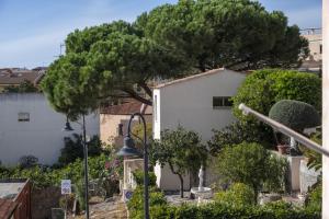 a white house with a tree in front of it at L'Orso e il Mare (Adults Only) in Palau