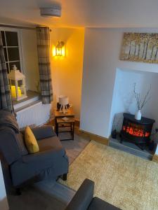 a living room with a couch and a fireplace at Castle Wall Cottage in Conwy