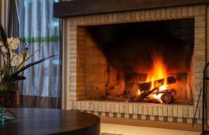 a brick fireplace with a fire in it at Hotel Laghetto Viale in Gramado