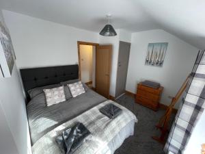 a bedroom with a large bed in a attic at Castle Wall Cottage in Conwy