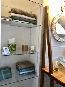 a glass shelf in a bathroom with towels at Le jardin des Vérottes in Beaune