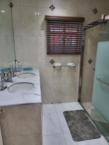 a bathroom with two sinks and a shower at The Royal at Meadowbrook 3 bed rooms house in Kingston