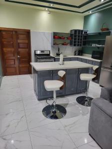 a kitchen with a counter and two bar stools at The Royal at Meadowbrook 3 bed rooms house in Kingston
