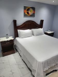 a bedroom with a large bed with white sheets at The Royal at Meadowbrook 3 bed rooms house in Kingston