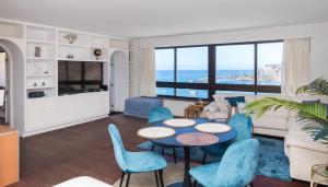 モガンにあるDoñana 1213 &1214, lux penthouseのテーブルと椅子とソファのあるリビングルーム