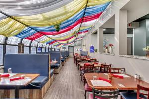 comedor con mesas y sillas y techo colorido en Suburban Studios Salt Lake City Airport en Salt Lake City
