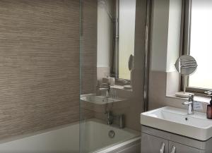 W łazience znajduje się szklana kabina prysznicowa i umywalka. w obiekcie Stunning "Orwell" Scandinave Lodge with Private Hot Tub w mieście East Bergholt
