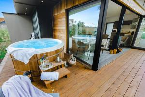 bañera de hidromasaje en la cubierta de una casa en Beautiful "Stour" Eco Lodge with Private Hot Tub, en East Bergholt