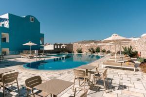 a pool with tables and chairs next to a building at Margarenia in Perissa