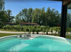 a large swimming pool in front of a house at "Brett" Scandinavian Lodge with private hot tub in East Bergholt