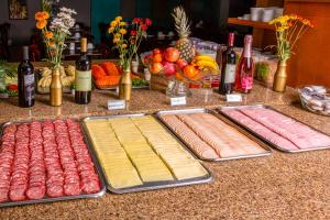 a table with different types of meats and bottles of wine at Hotel Laghetto Viale in Gramado