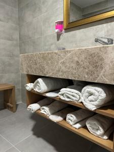 bagno con mensola, asciugamani e specchio di GRAND DELUX HOTEL a Samsun