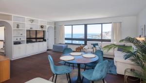 a living room with a couch and a table and chairs at 100 m2 Penthouse on the beach. in Patalavaca