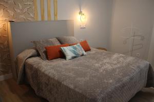 a bedroom with a bed with orange and blue pillows at Apartamento reformado centro de Santander in Santander