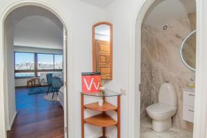 a bathroom with a toilet and a view of a room at 100 m2 Penthouse on the beach. in Patalavaca +28 photos
