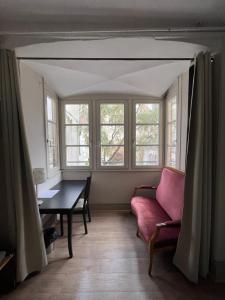 a living room with a couch and a table and windows at Hôtel Patricia - Strasbourg Hyper Centre in Strasbourg